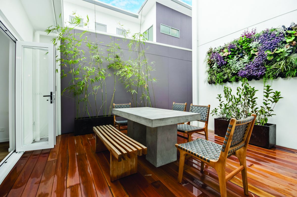 Enclosed outdoor patio, with cement table and green wall