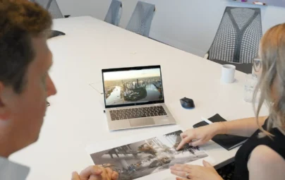 People interacting with laptop and documents in a meeting