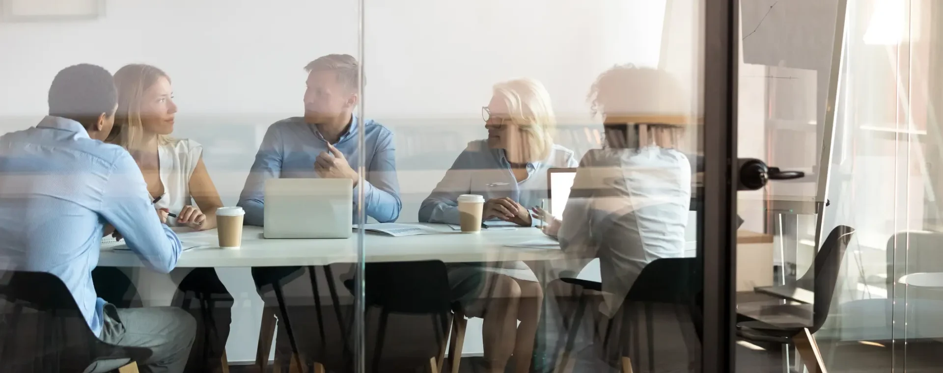 Group meeting in a conference room behind glass