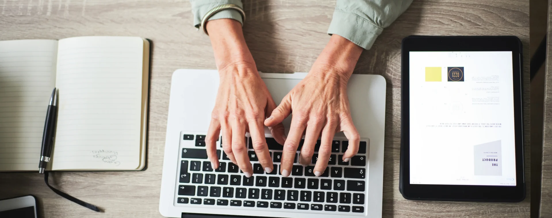 Hands interacting with a laptop on a desk