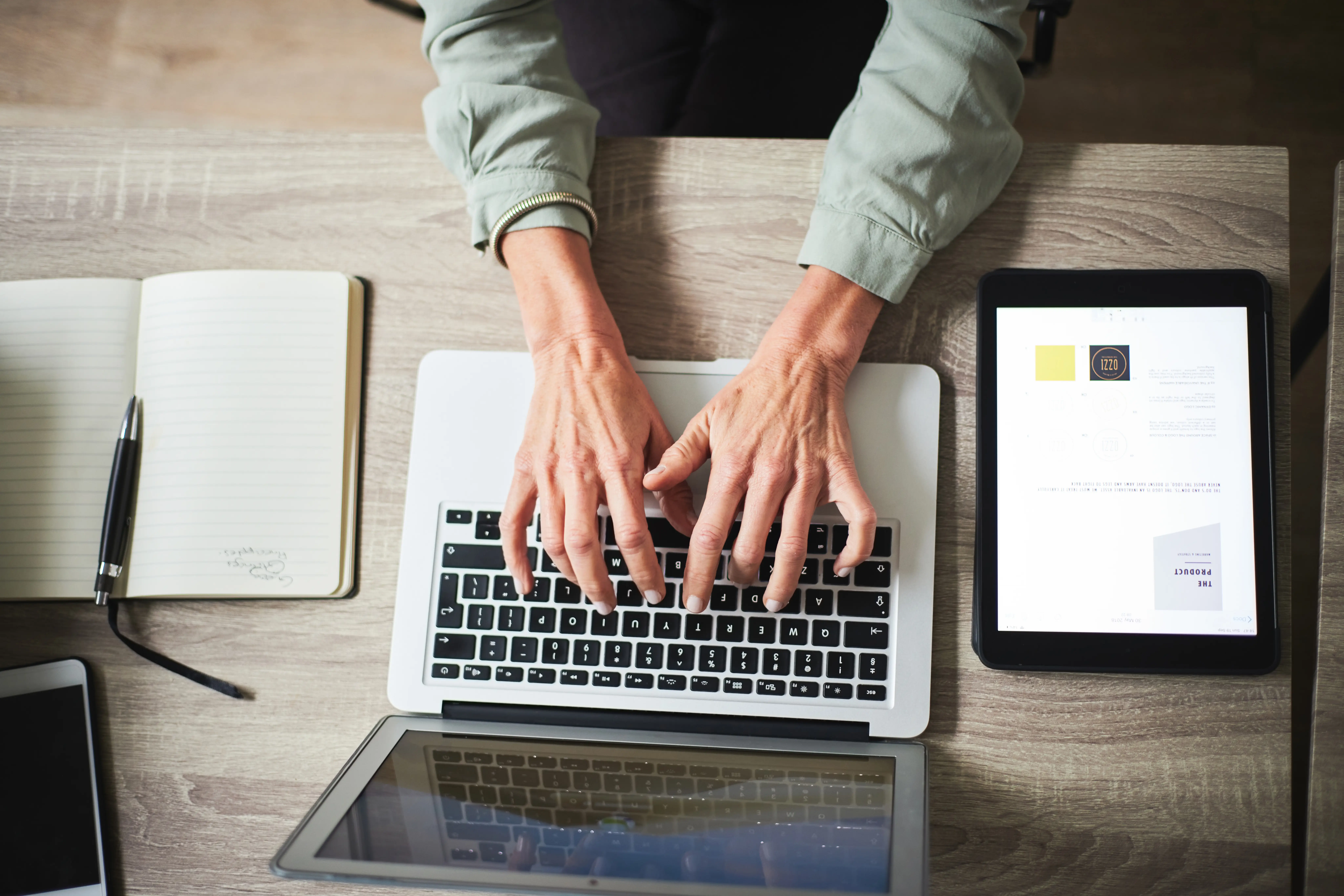 Hands interacting with a laptop on a desk