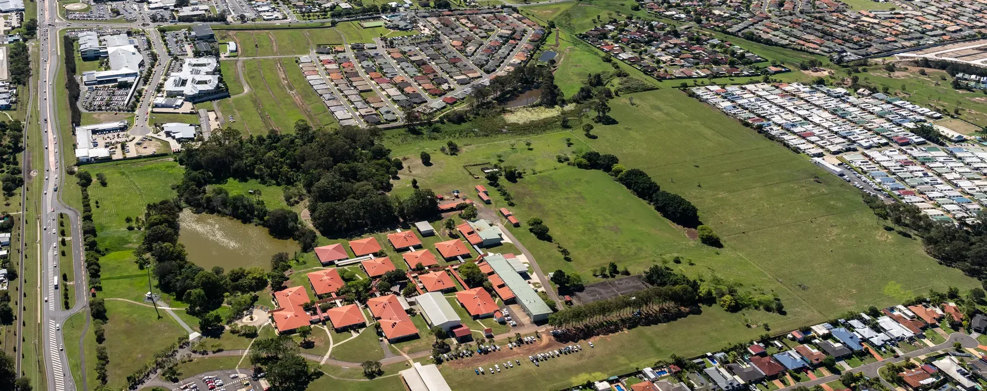 Aerial view of Hervey Bay featuring residential suburbs, open green space and surrounding urban development