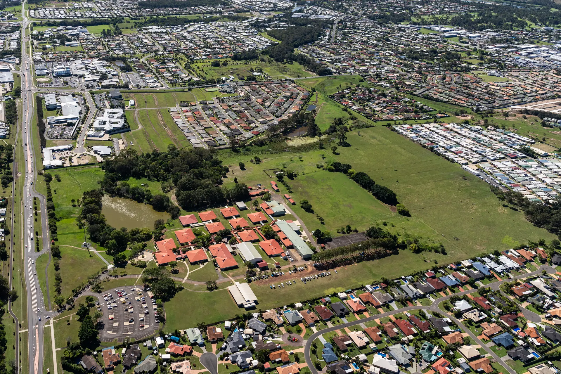 Aerial view of Hervey Bay featuring residential suburbs, open green space and surrounding urban development